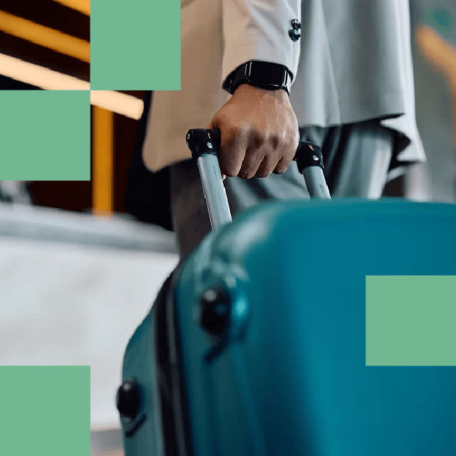 person pulling suitcase through airport