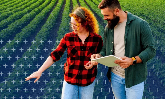 two people on a farm with a tablet observing crops