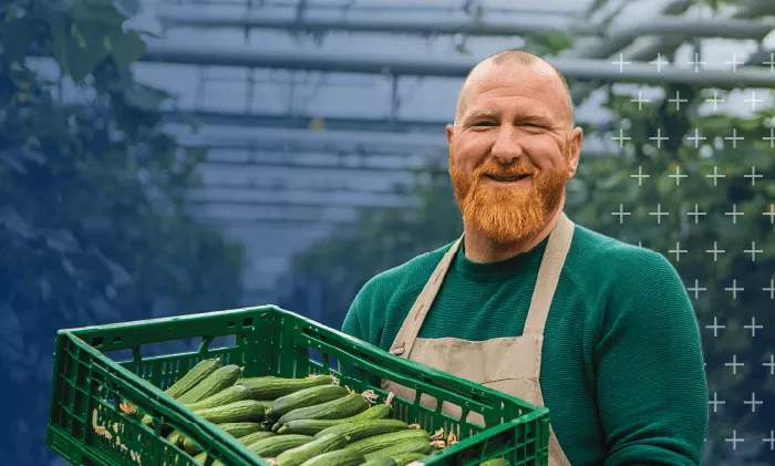 person smiling with crate of zucchini