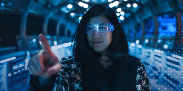 person wearing digital looking blue glasses while tapping a screen that is not visible in the air