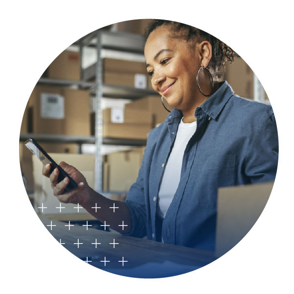 Small business owner in room with packages checking phone