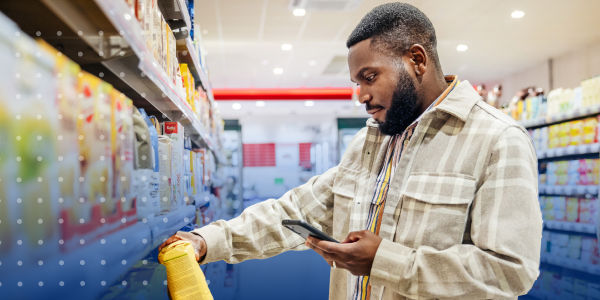 warehouse worker holding tablet and reviewing shelves stocked with product in warehouse