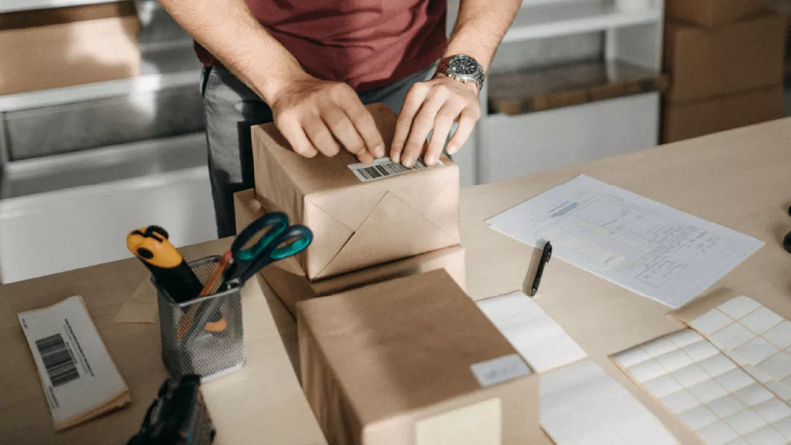 A man packs shipments, attaching a barcode with the GS1 Company prefix