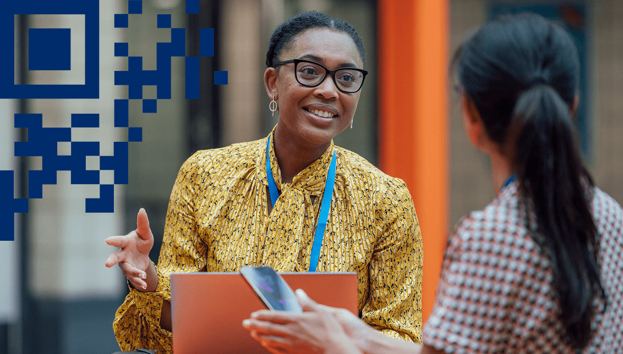 Conference attendees networking with a clipboard and 2D carrier in left corner