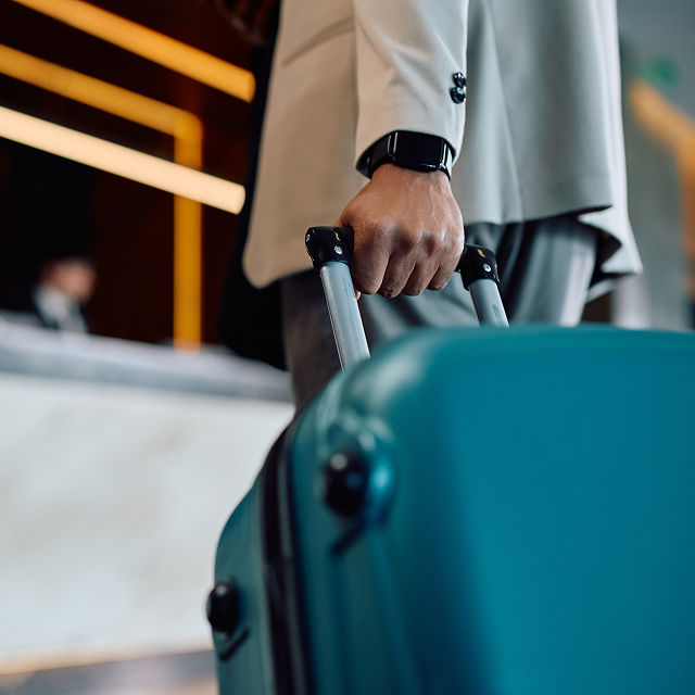 person pulling suitcase through airport