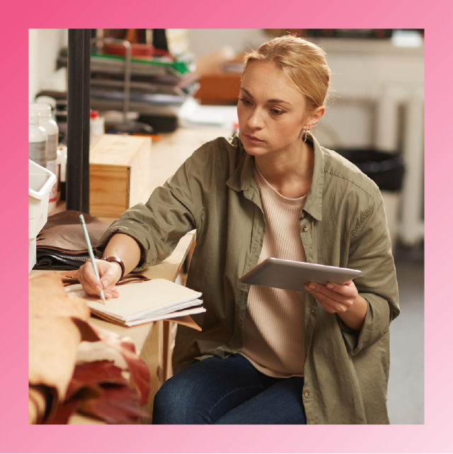 Small business owner reviewing product data with tablet