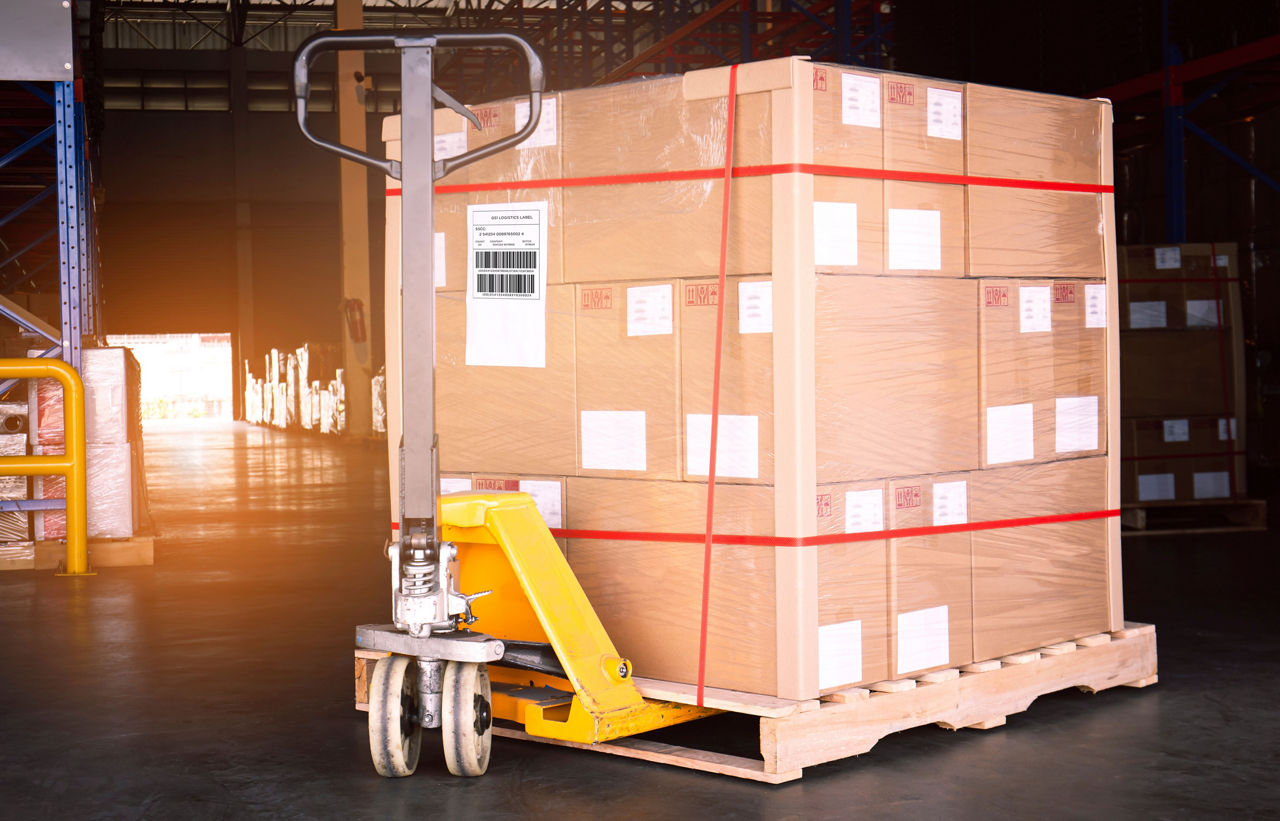 Cargo shipment box pallet, Manufacturing and warehousing. Heavy goods pallet with hand pallet truck at the warehouse storage.