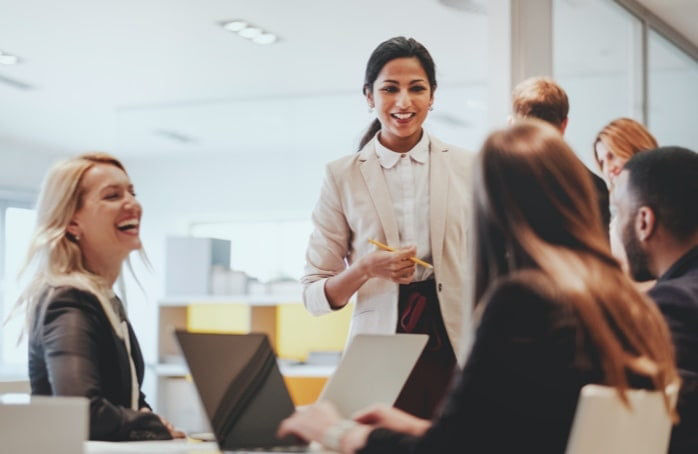 Woman in white shirt collaborating at GS1 US with a group of coworkers